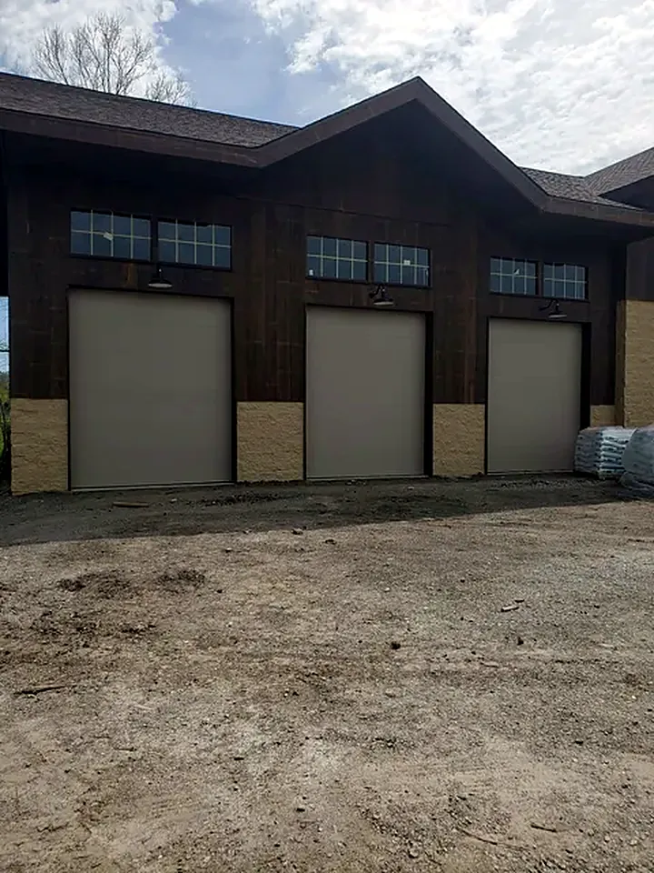 Three tall overhead doors on a new shop building