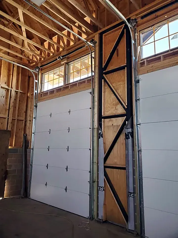 Inside view of a tall overhead door installation with track and framing